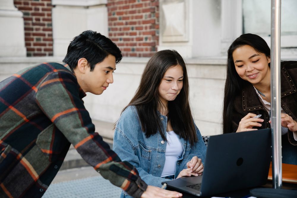 Students researching private university admission together on a laptop