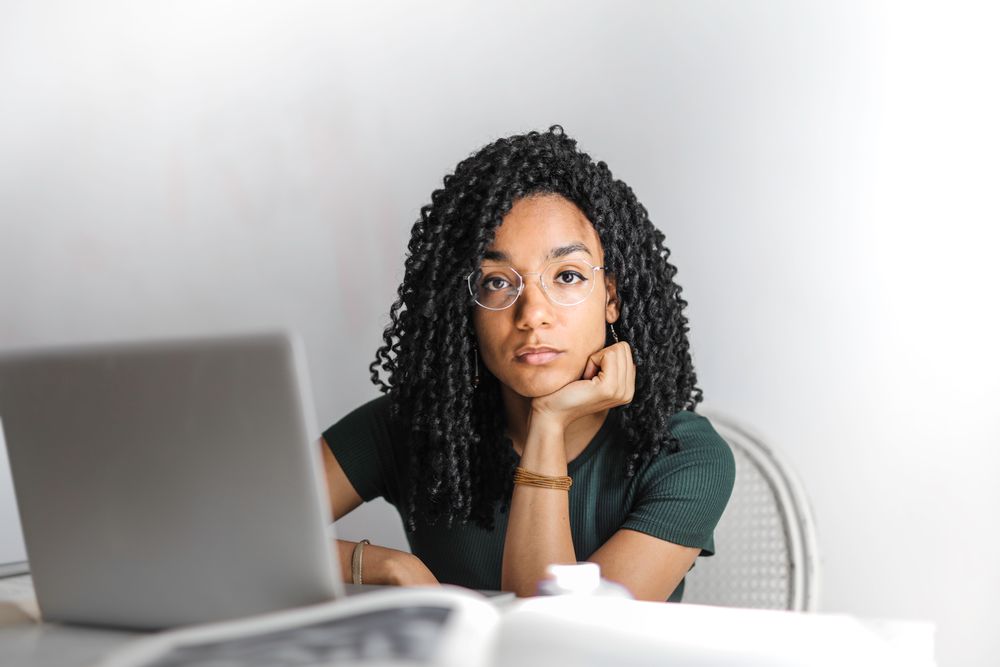 A young woman scrutinising information on her laptop before making a decision